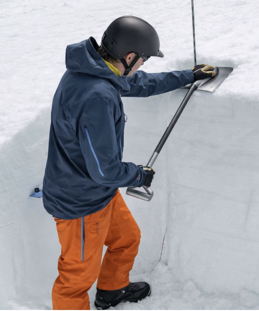 Guide collecting snow observations in a pit.